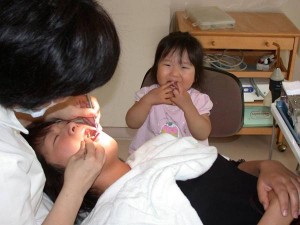 歯科医院で親の治療を待っている幼児